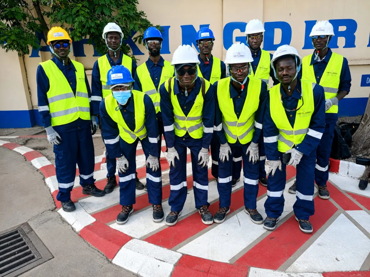 Team tecnico NETLOGIK in tenuta da cantiere, caschi e gilet di sicurezza