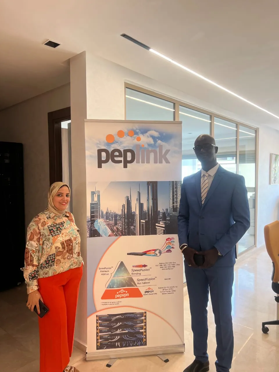 Incontro con un partner davanti a un roll-up Peplink